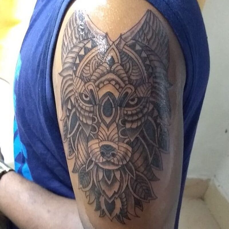 Ornate tribal wolf mandala shoulder tattoo for men