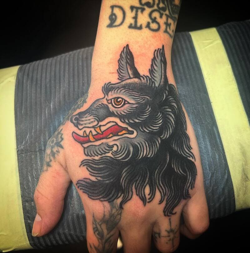 Traditional style wolf head hand tattoo for men
