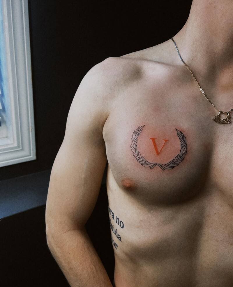 small-laurel-wreath-initial-chest-tattoo-men