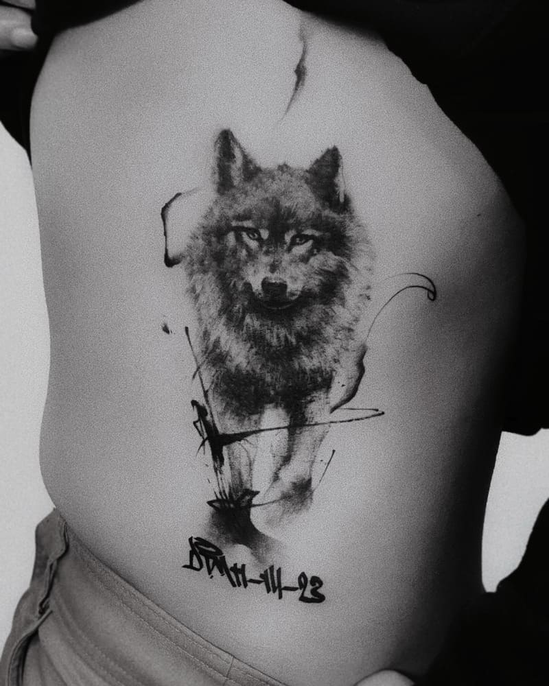 Solitary wolf side body tattoo with artistic brush strokes for men