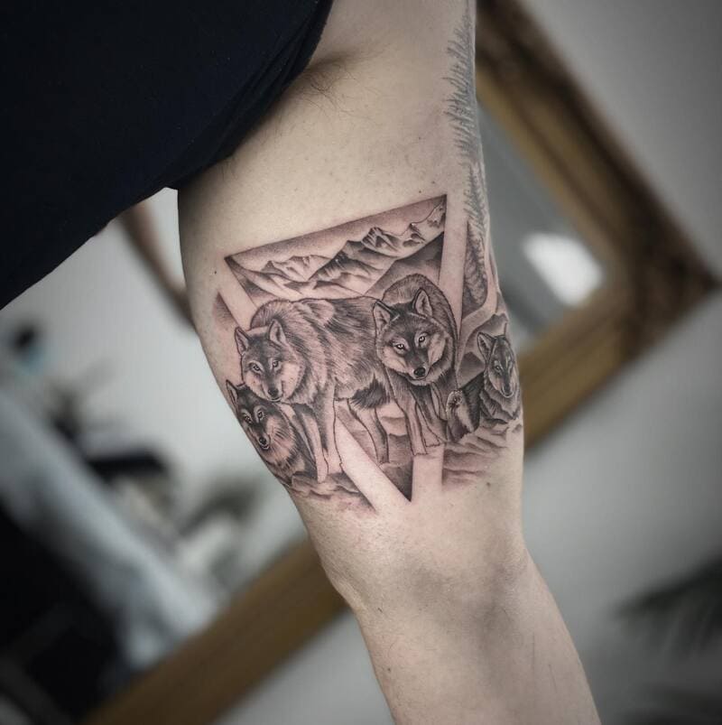 Geometric wolf pack mountain scene arm tattoo for men