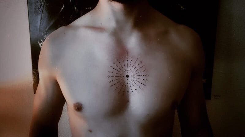 dotwork-sunburst-small-center-chest-tattoo-men