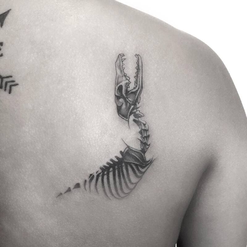 Minimalist wolf spine skull tattoo for men