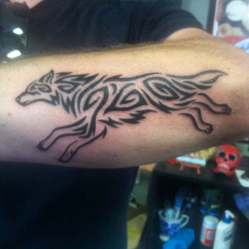 Running tribal wolf arm tattoo design for men
