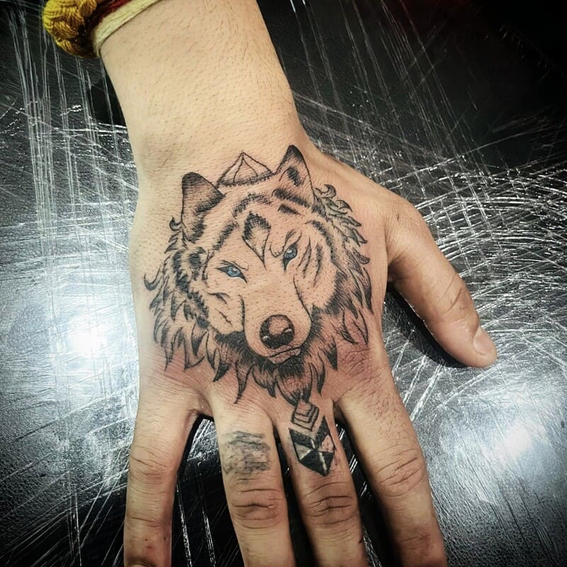 Gentle wolf portrait hand tattoo with geometric elements for men