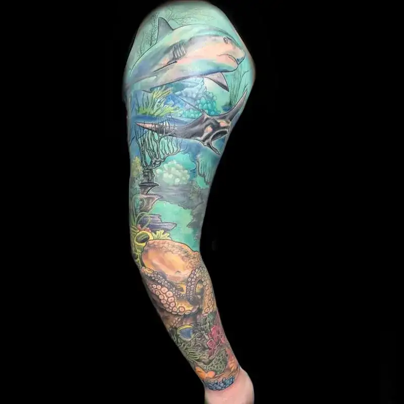 Colorful full arm ocean sleeve tattoo for men with sharks and octopus ecosystem design