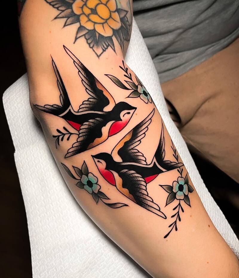 Traditional swallow and flower forearm tattoo design for men