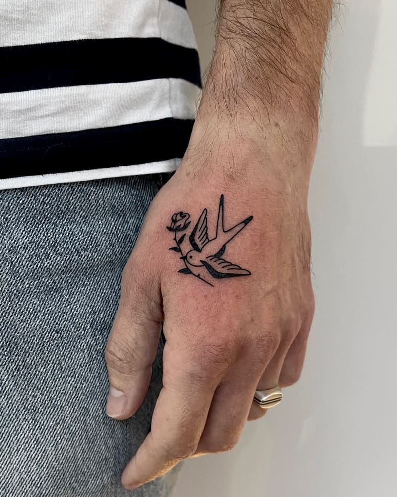 Minimal floral swallow hand tattoo design for men