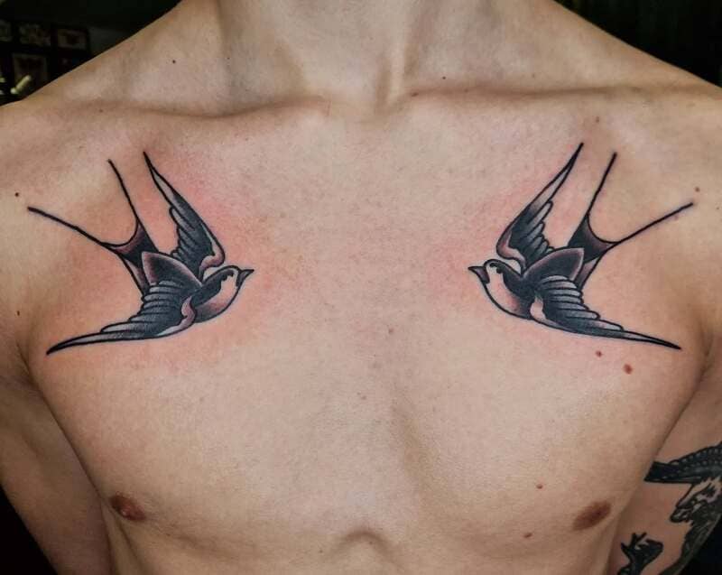Bold navy swallow chest tattoo design for men