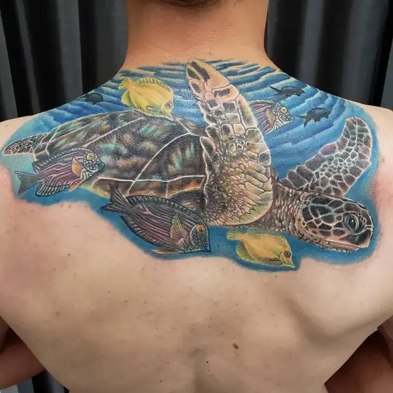 Colorful sea turtle ocean back tattoo for men with tropical fish and blue water