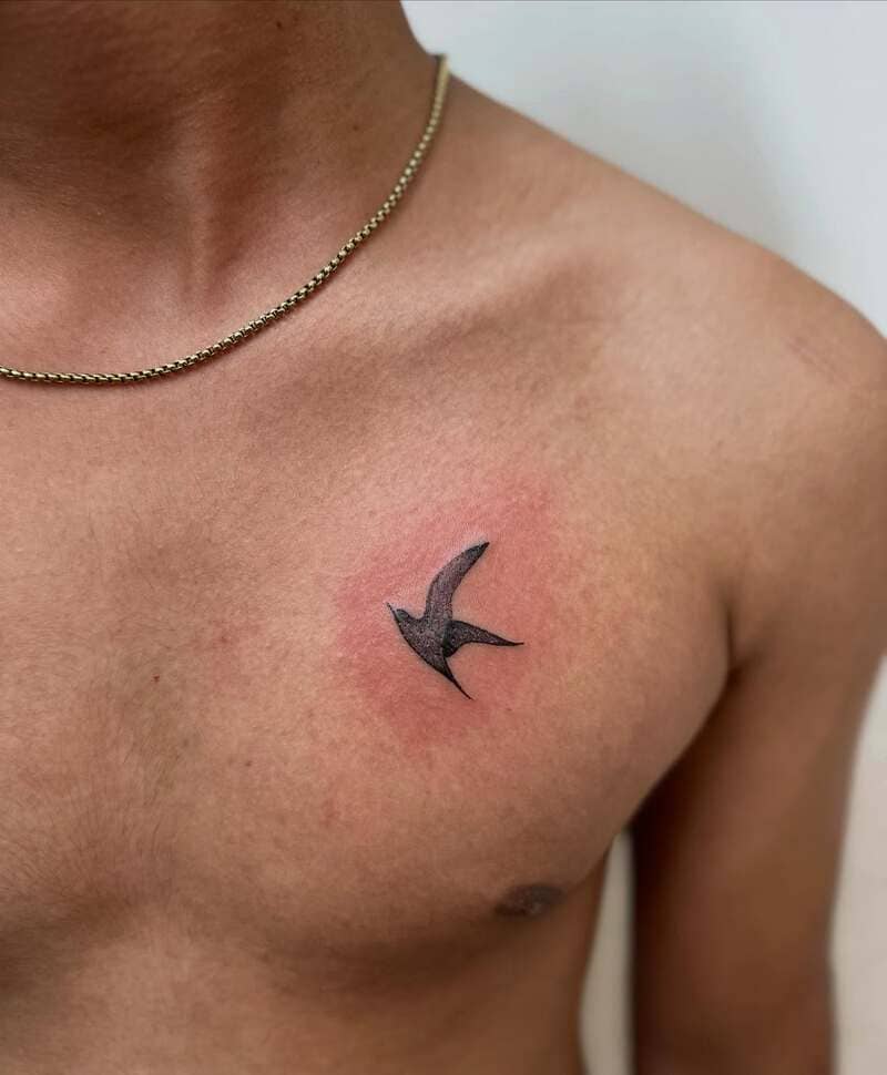 Minimal single swallow chest tattoo design for men
