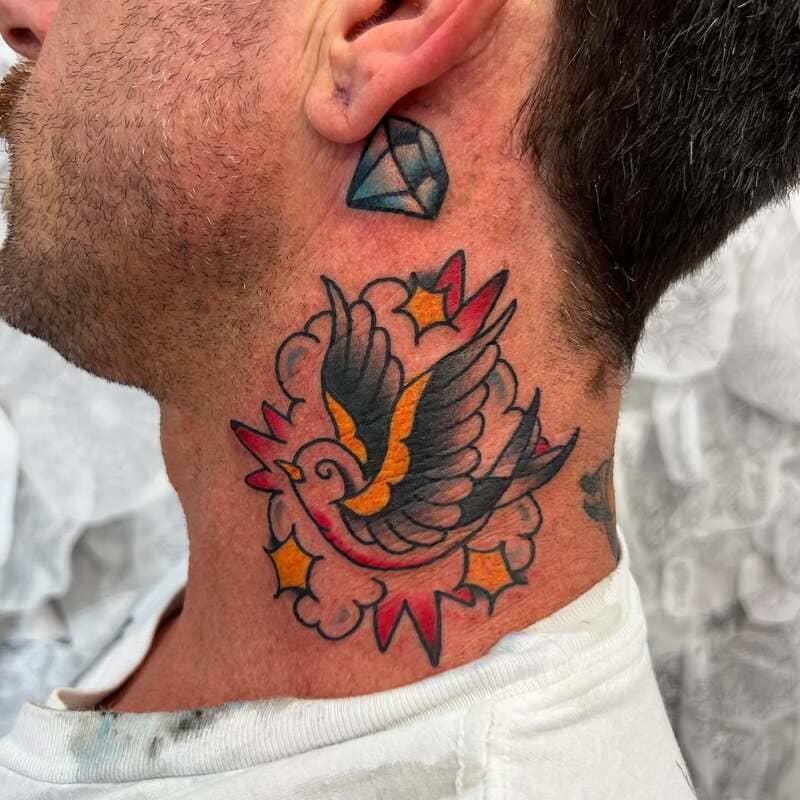 American traditional swallow tattoo with stars on neck