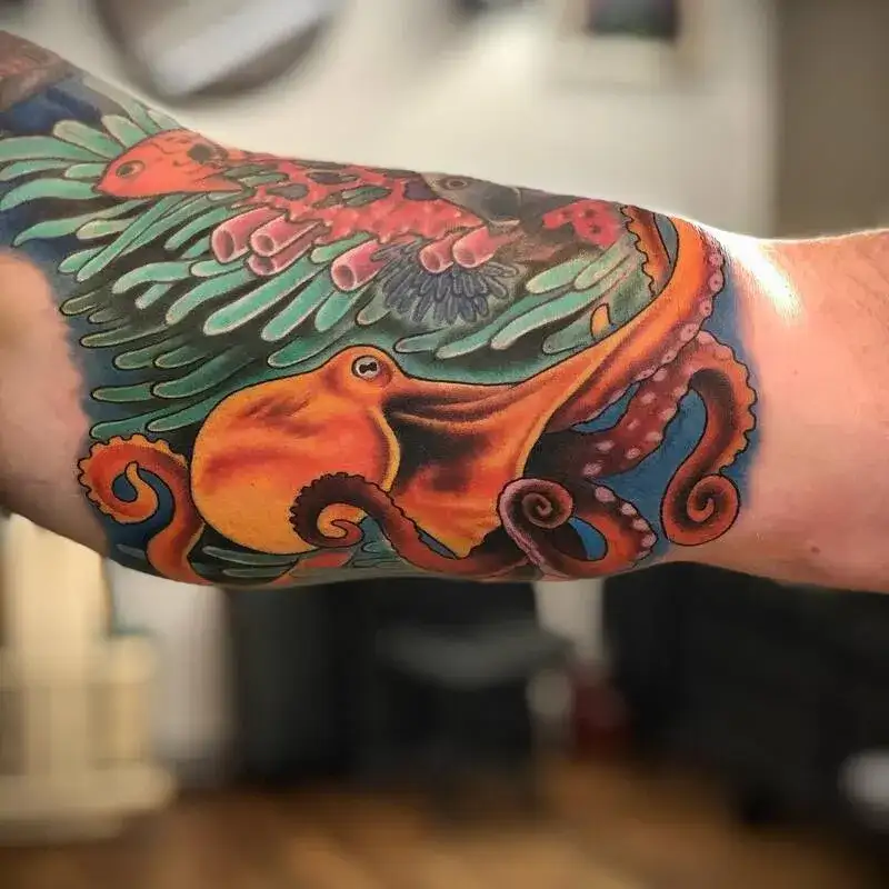 Bright orange octopus with teal coral vibrant ocean tattoo for men