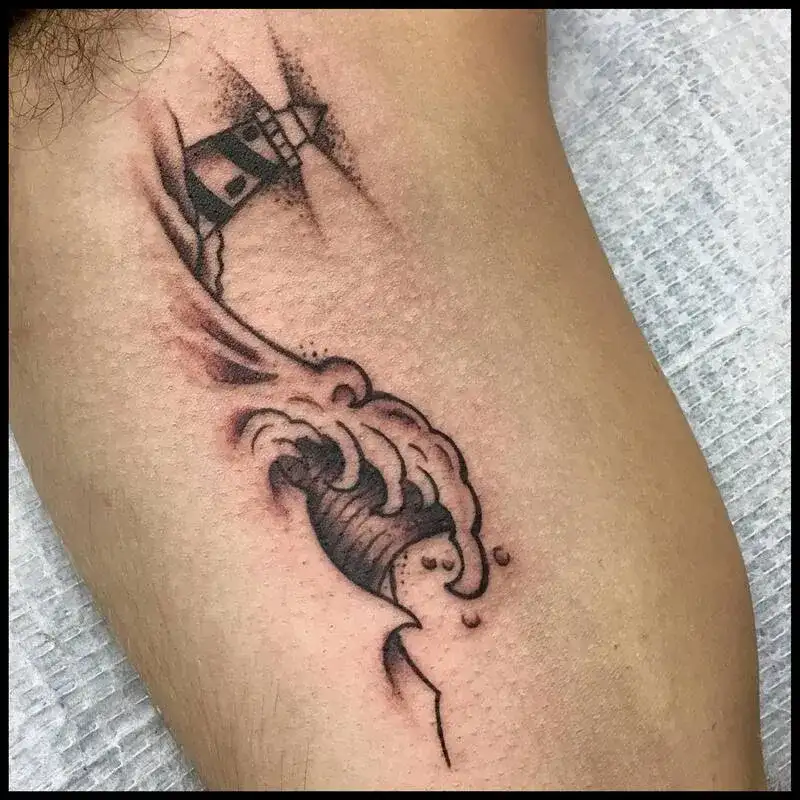 Small lighthouse with crashing wave black work ocean tattoo for men