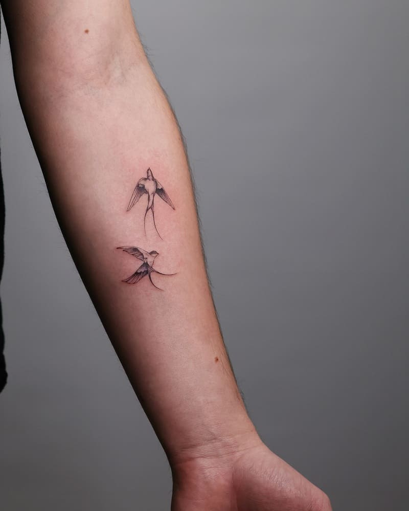 Minimalist paired swallow forearm tattoo design for men